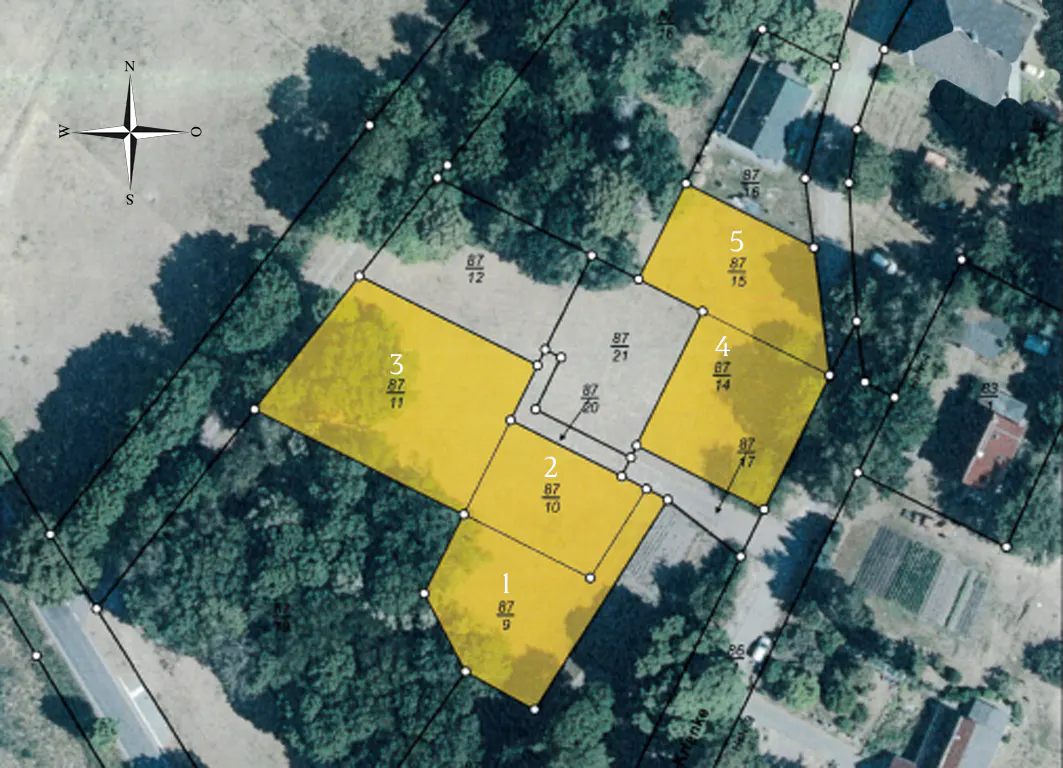 Aerial view of five yellow lots, numbered 1-5, surrounded by trees and roads. A compass rose is in the upper left corner.