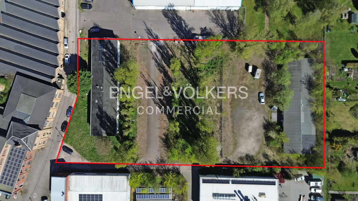 Aerial view of a commercial property outlined in red, featuring a building, trees, and the Engel & Volkers Commercial logo.