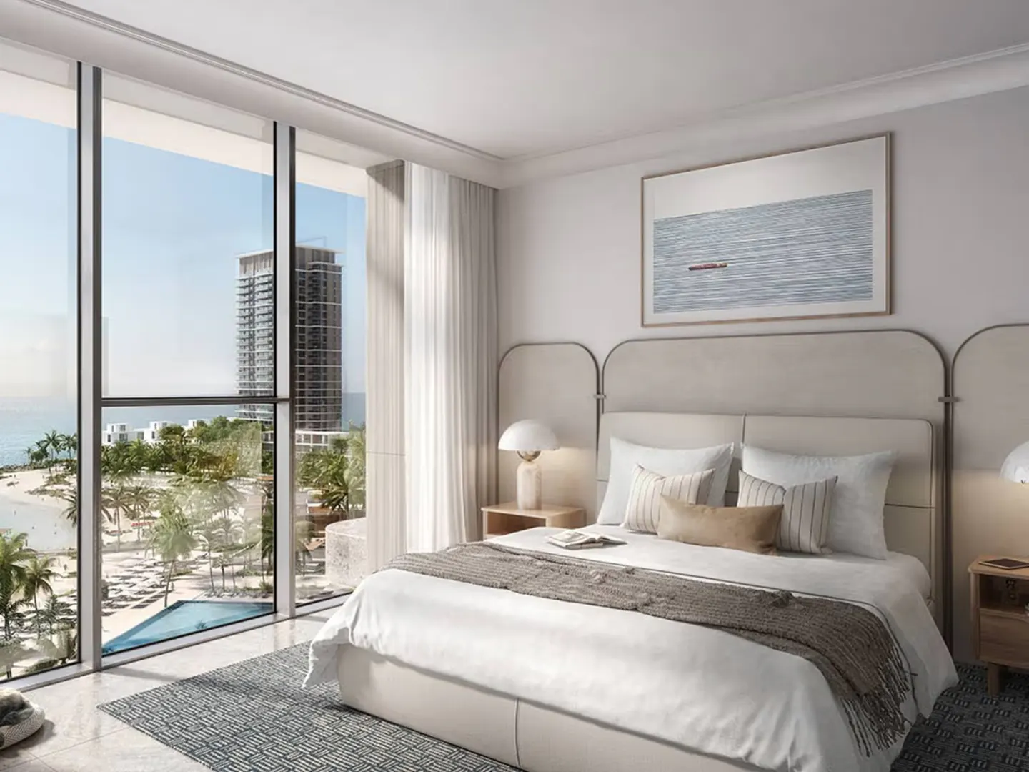 Bright bedroom with a king bed, white linens, and a gray throw. Large windows overlook a beach, palm trees, and a high-rise building.