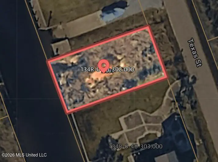 Aerial view of a vacant lot outlined in red, next to water and Texas St, with parcel number 134R-0-35-302.000.