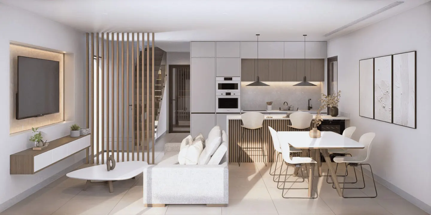 A bright, modern living space with a white sofa, TV, kitchen with bar stools, and a dining table with chairs.