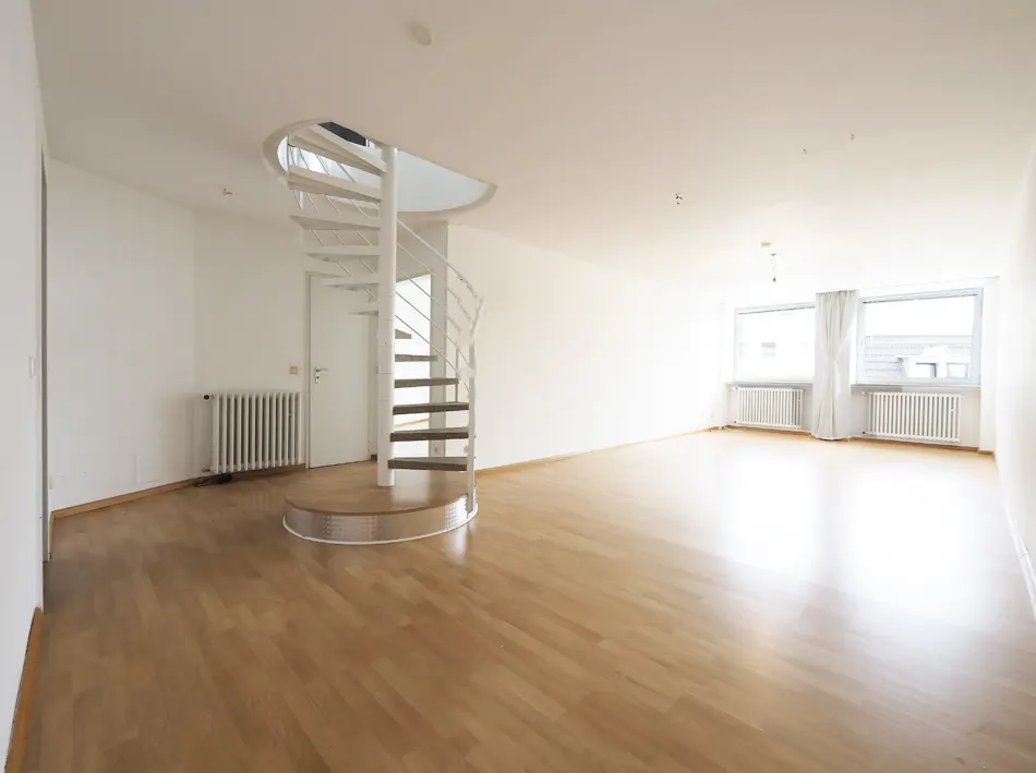 Bright, open living room with light wood floors, white walls, and a white spiral staircase leading to an upper level.