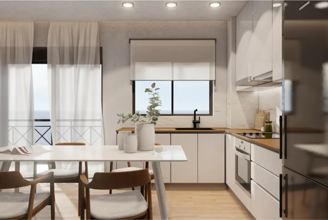 Bright kitchen with white cabinets, wood countertops, and a black sink. A white table with wood chairs sits in front of a window with sheer curtains.