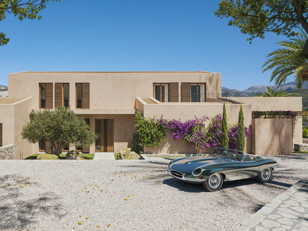 Beige two-story house with brown shutters, purple flowers, and a green vintage car parked in the gravel driveway.