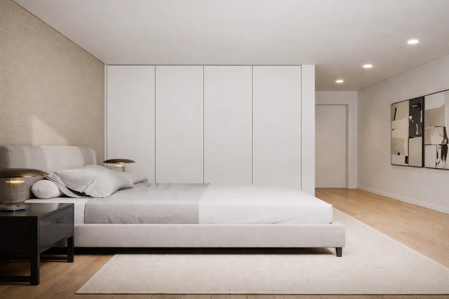 A modern bedroom with a light gray bed, white linens, and a dark nightstand. A large white wardrobe is against the wall.