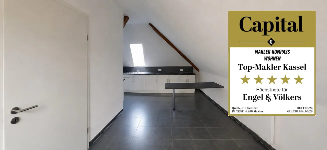 Attic apartment with white walls, gray tile floor, and a small kitchen area. A "Top-Makler Kassel" award is displayed.