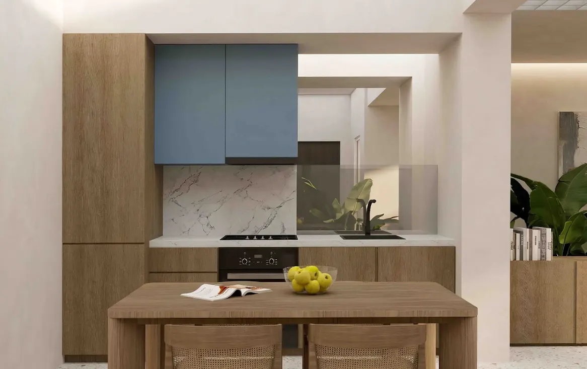 A modern kitchen with wood cabinets, blue upper cabinets, and marble backsplash. A wooden table with a bowl of apples and a magazine sits in the foreground.