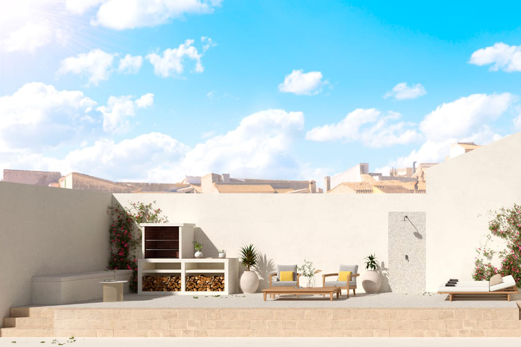 Sunny outdoor patio with a stone grill, wood storage, two armchairs, a coffee table, and a lounge chair under a blue sky.