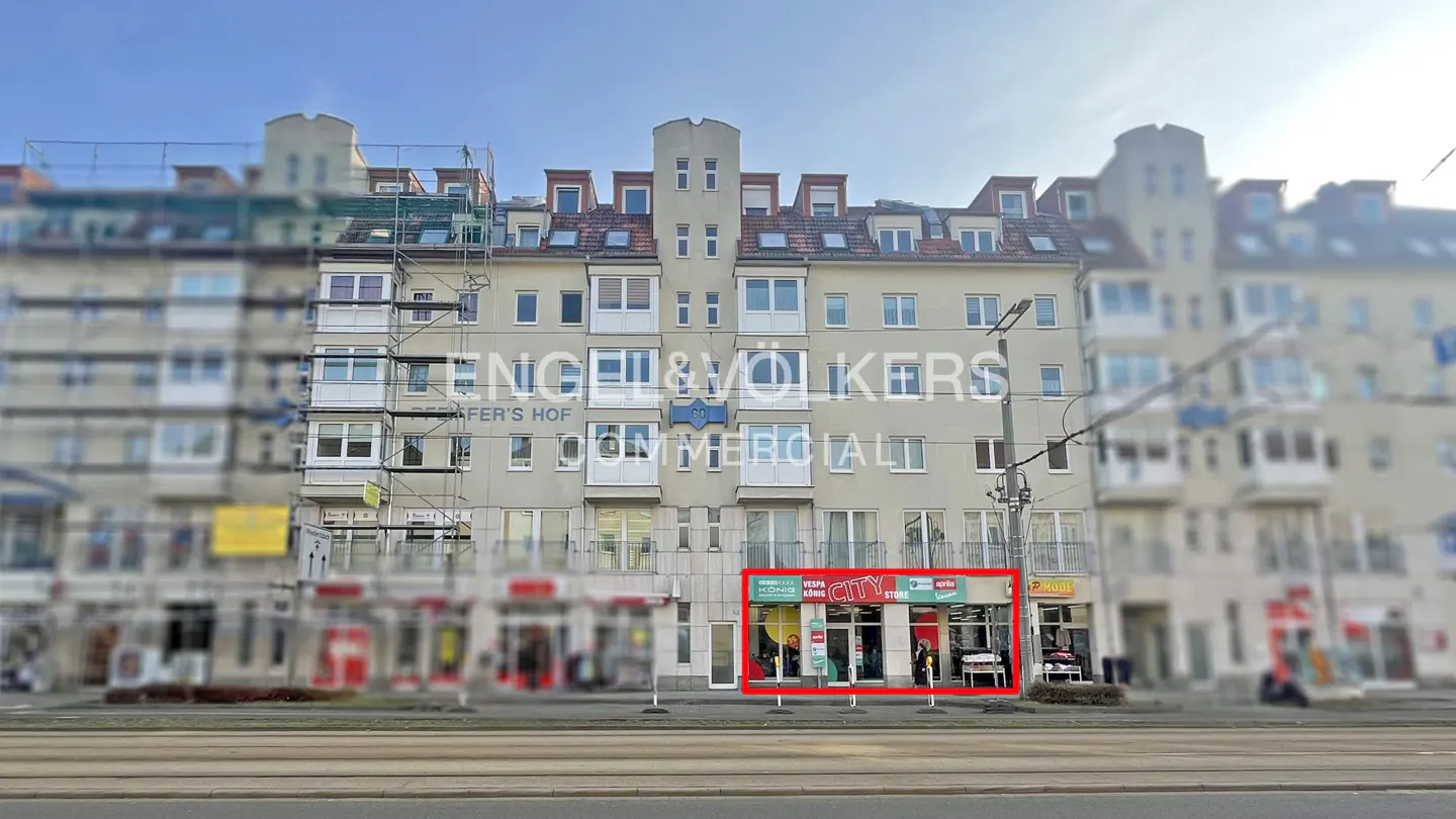 Exterior of a commercial building with a "CITY STORE" highlighted in a red square. "Engel & Volkers Commercial" is on the building.