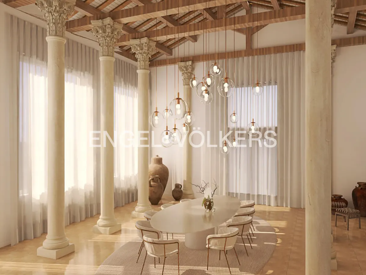 Bright dining room with white columns, wood ceiling beams, and sheer curtains. A white oval table is surrounded by chairs under globe pendant lights.
