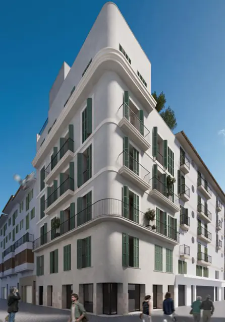 Exterior view of a multi-story white building with green shutters and balconies, people walking on the sidewalk.