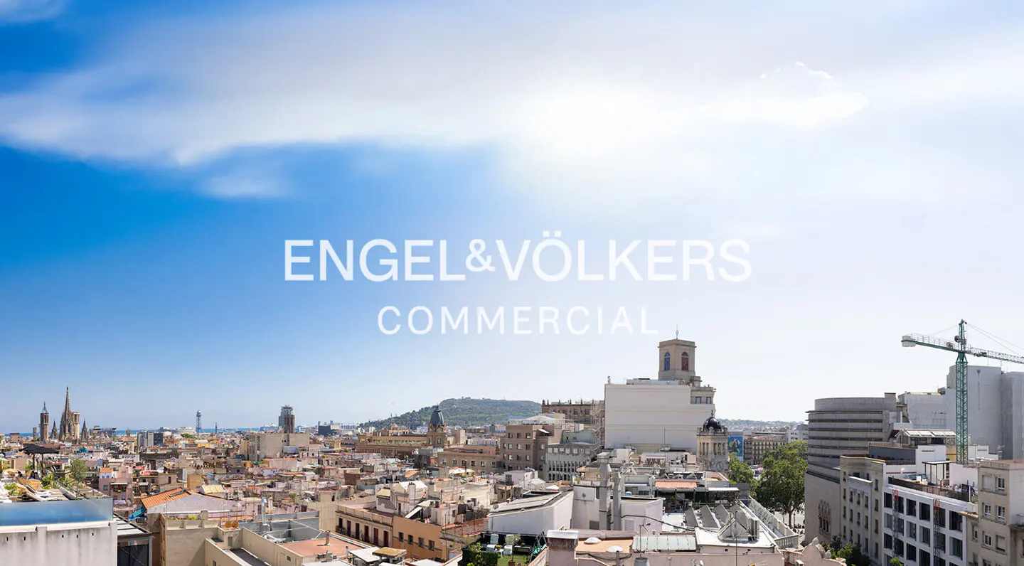 Engel & Völkers Commercial logo over a Barcelona cityscape under a blue sky with clouds.