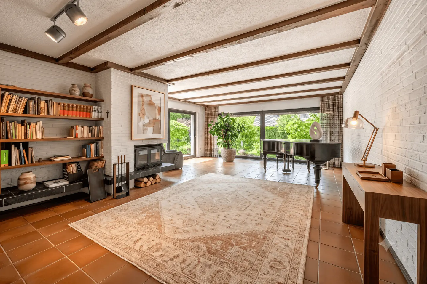 A spacious living room with a piano, fireplace, and large windows. The room has a beige rug, terracotta tile floors, and a bookshelf.