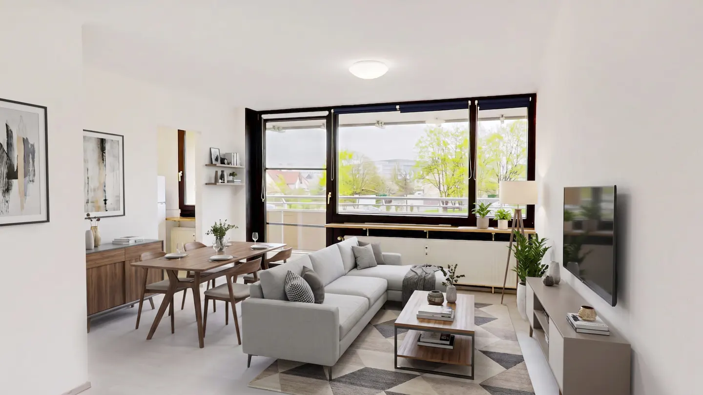 Bright living room with a gray sofa, wood dining table, and large windows overlooking a green landscape.