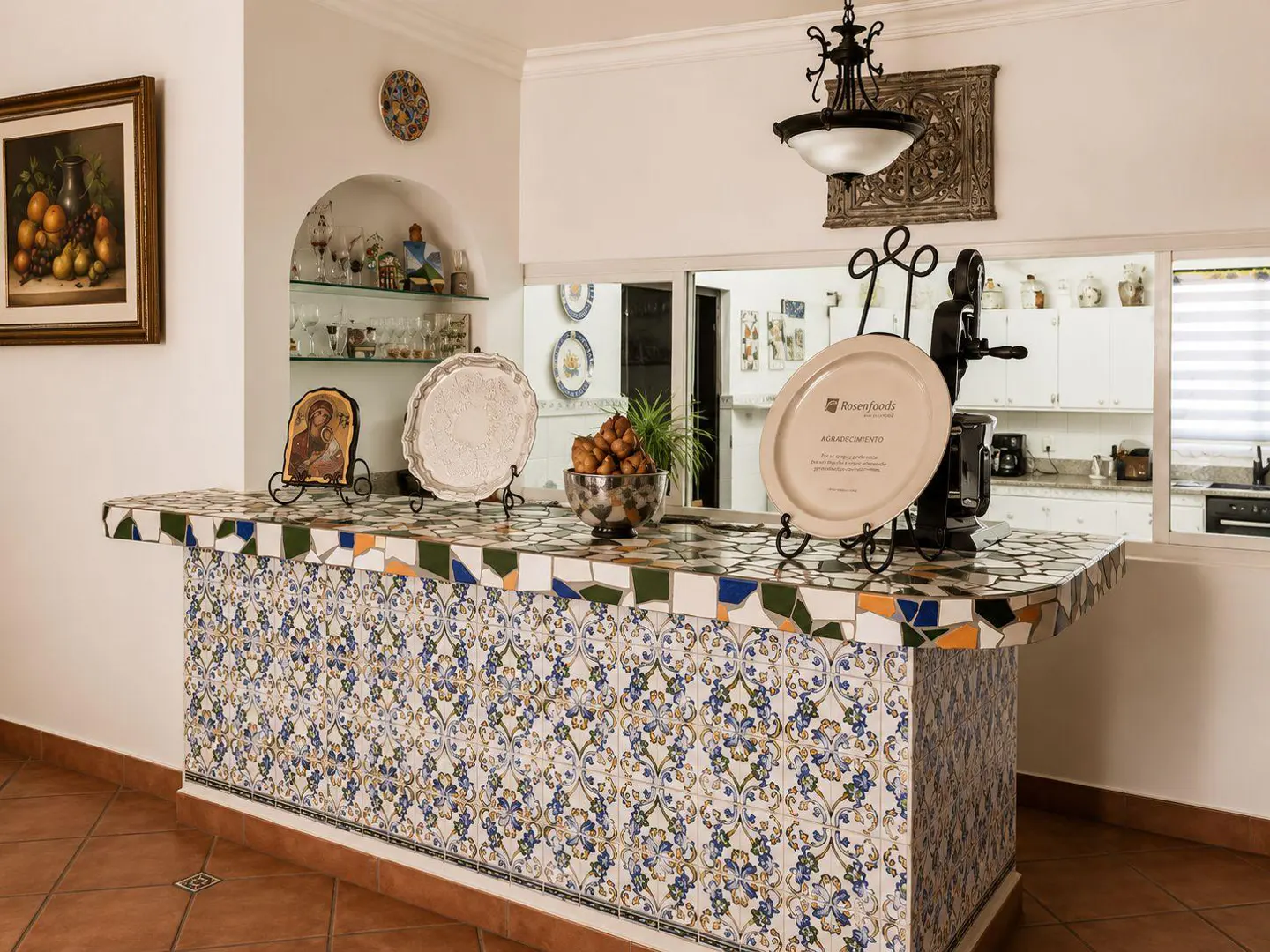 A kitchen bar with blue and white patterned tiles, plates on stands, and a bowl of food.