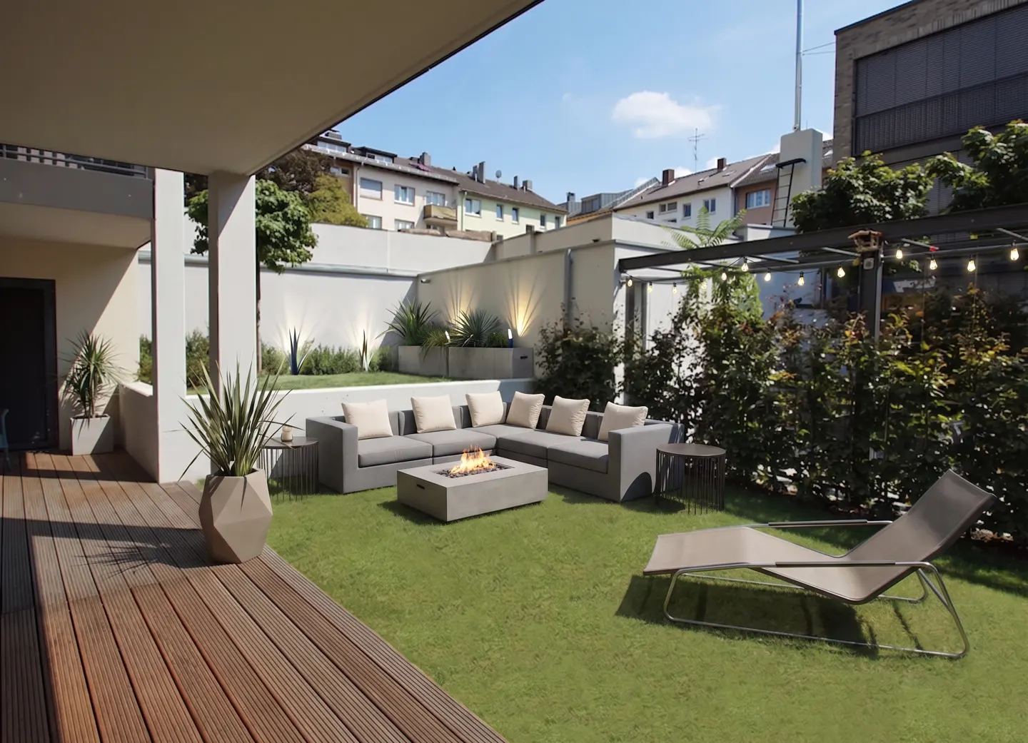 Outdoor patio with gray sectional sofa, fire pit, lounge chair, and wood deck on artificial grass.