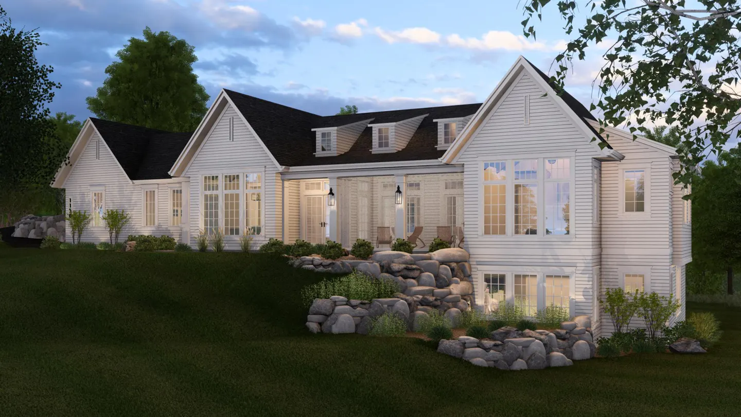 Exterior view of a white, two-story house with a black roof, large windows, and a covered porch with chairs. The house is set on a green lawn with rock landscaping.