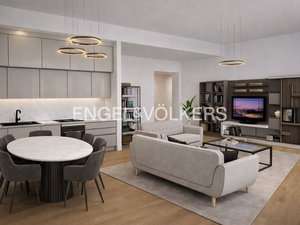 A modern apartment interior with a kitchen, dining area, and living room. The color palette is neutral, with light gray cabinets and sofas. A round table with chairs is in the foreground.