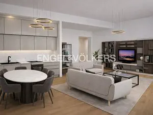 A modern apartment interior with a kitchen, dining area, and living room. The color palette is neutral, with light gray cabinets and sofas. A round table with chairs is in the foreground.