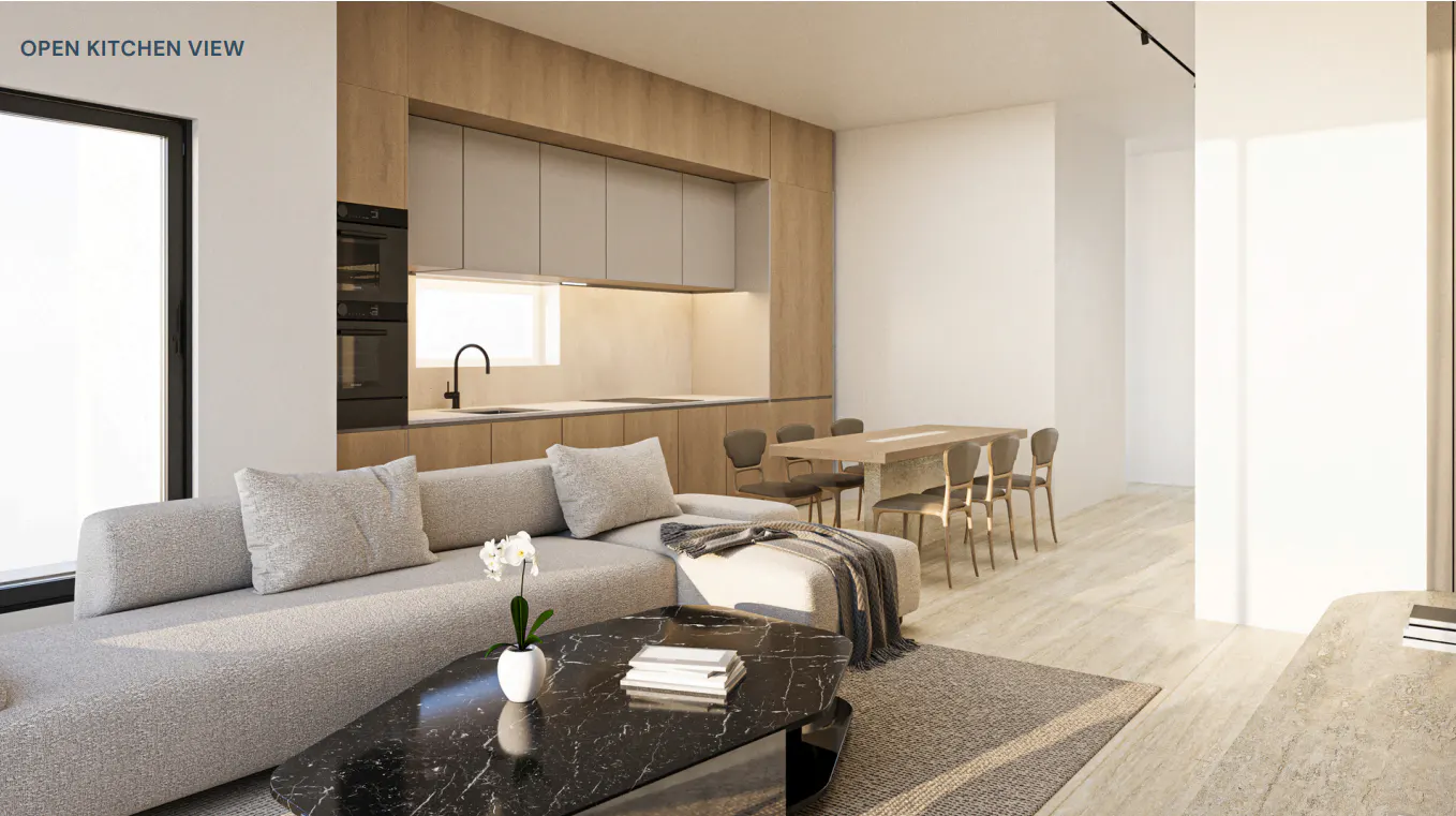 Open kitchen view featuring a gray sofa, black marble coffee table, and a dining table with chairs. The kitchen has wooden cabinets and stainless steel appliances.