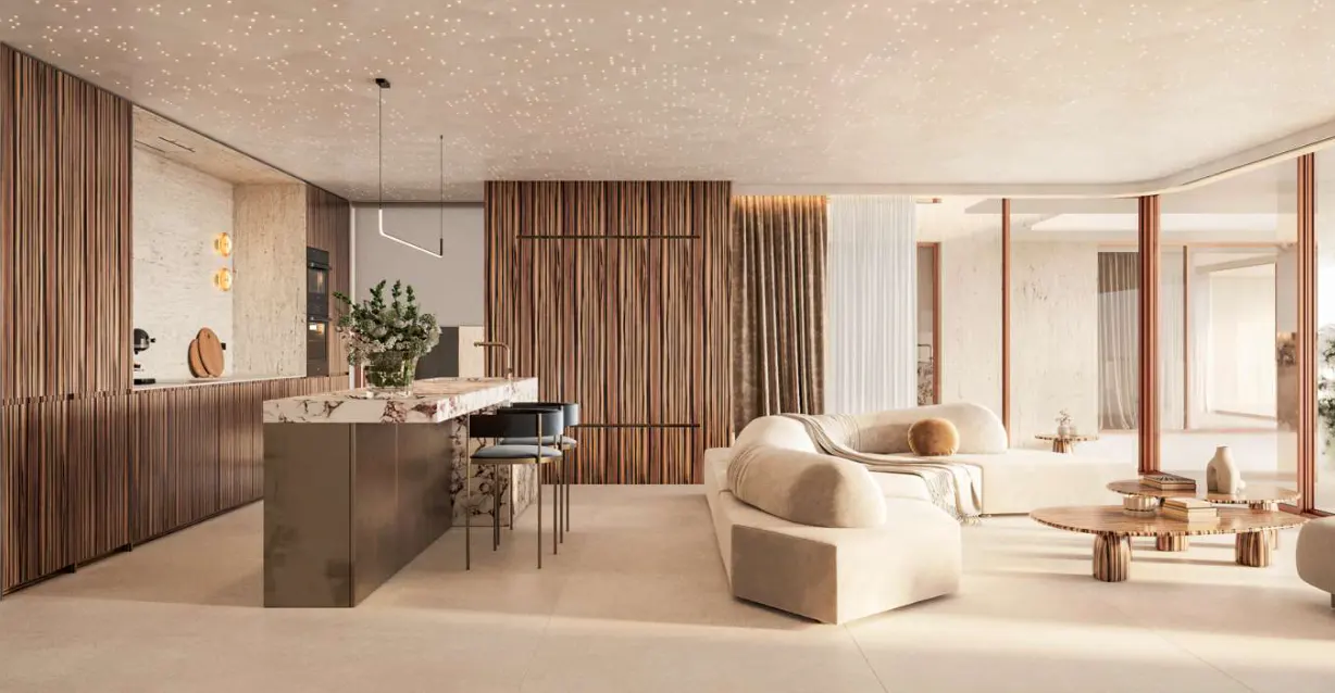 A modern living room with a kitchen island, a beige sofa, and wooden walls. The ceiling has small, star-like lights.