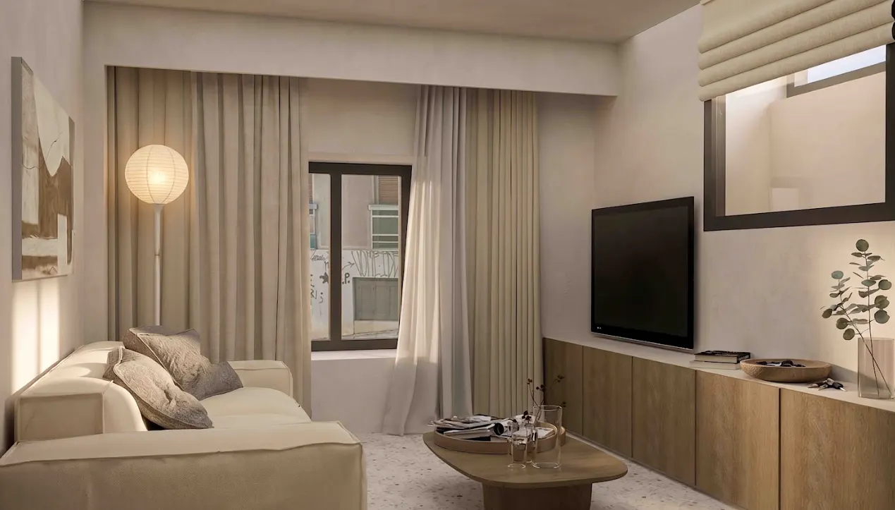 Living room with a cream sofa, wood coffee table, and a large TV on a wood cabinet. A window with curtains is on the left.