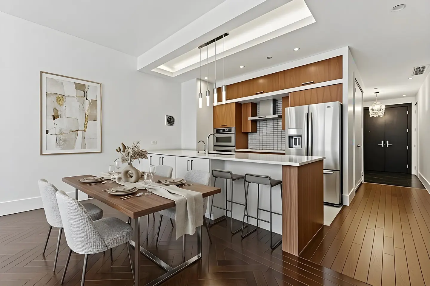 A modern kitchen and dining area with wood floors, white walls, and stainless steel appliances. A dining table with chairs is in the foreground.