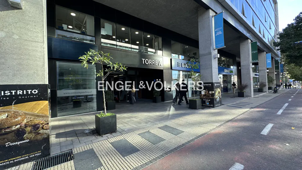 Exterior view of the Engel & Völkers office in a modern building with glass windows and blue banners.
