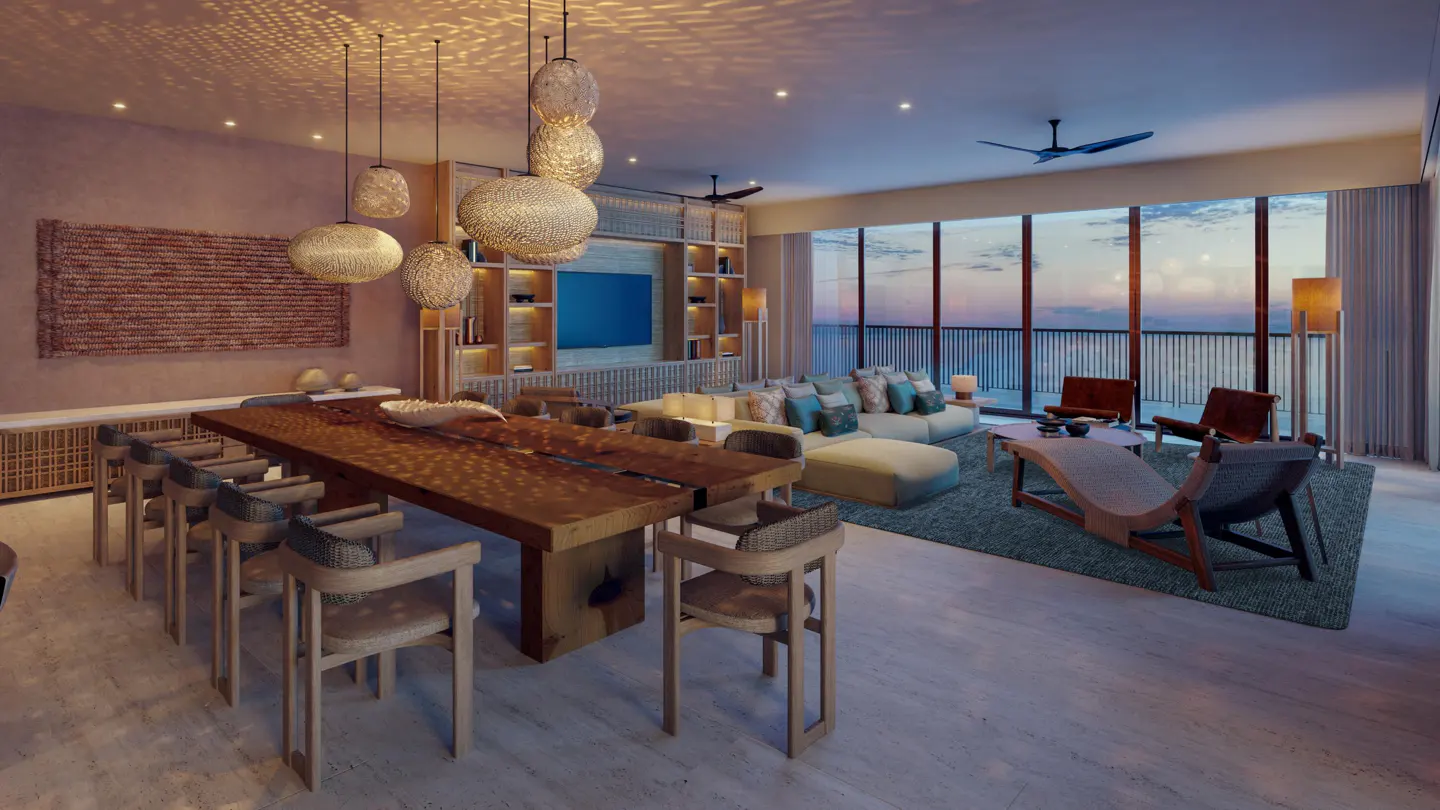 A spacious living room with a large wooden table, chairs, and a sofa facing a window with an ocean view.