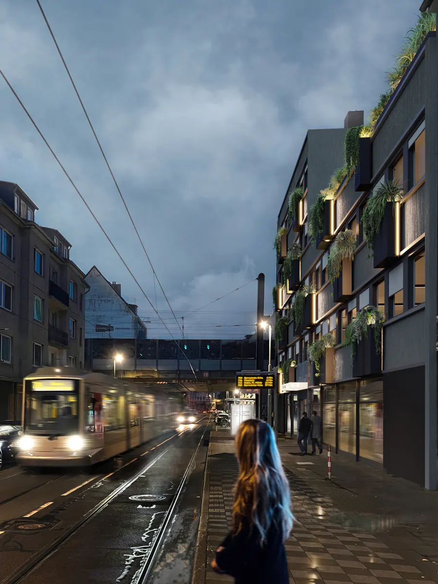 Modern apartment building with green planters on balconies, seen from a tram stop at dusk. A tram is blurred in motion.