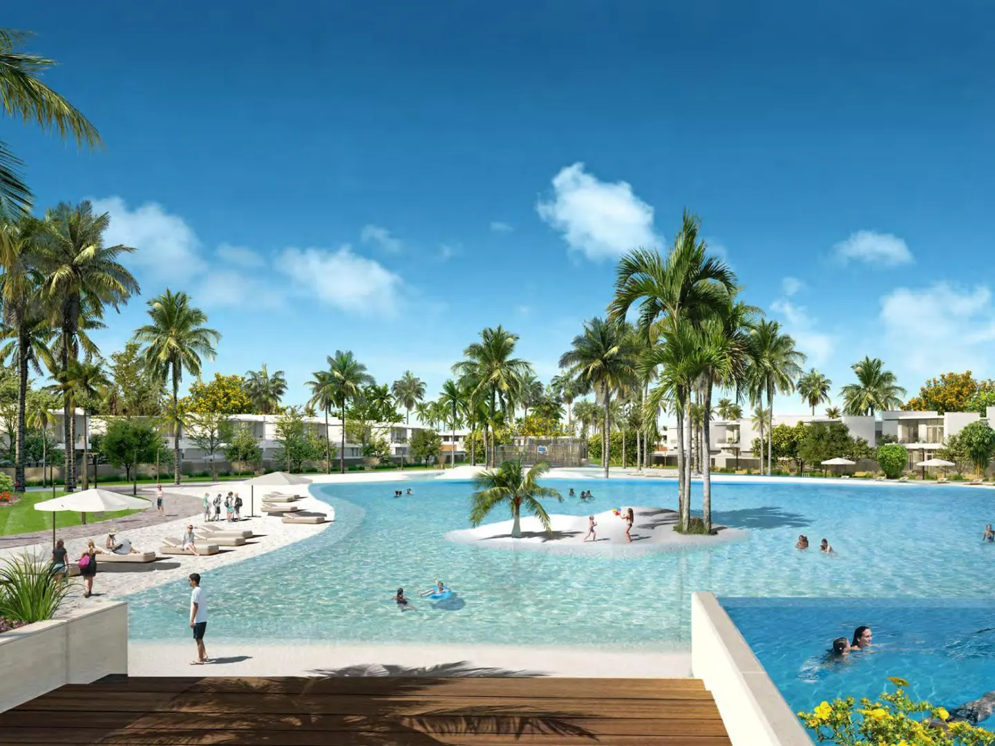 Scenic view of a resort with a lagoon, palm trees, white sand beach, and people swimming under a blue sky.