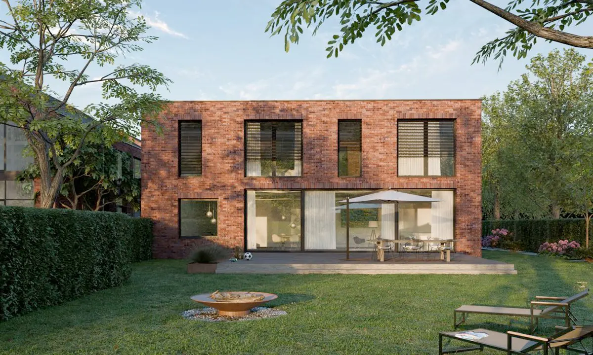 Modern red brick house with a patio, outdoor dining set, fire pit, and lounge chairs in a lush green backyard.