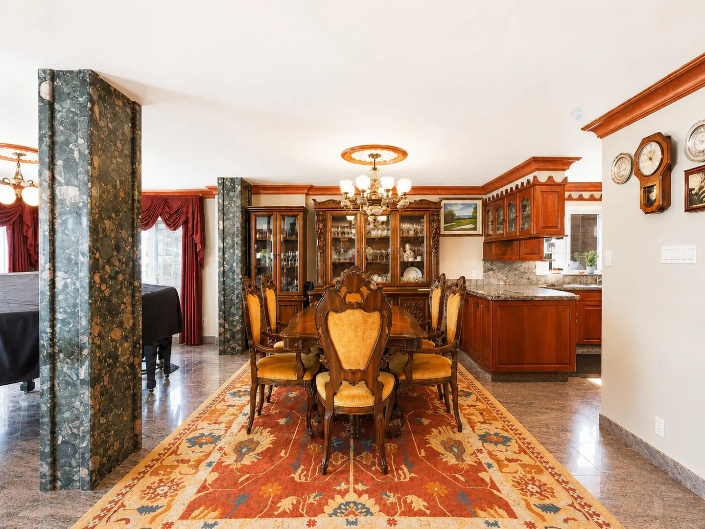 A dining room with a wooden table, yellow chairs, and an ornate rug. A piano and kitchen are visible in the background.