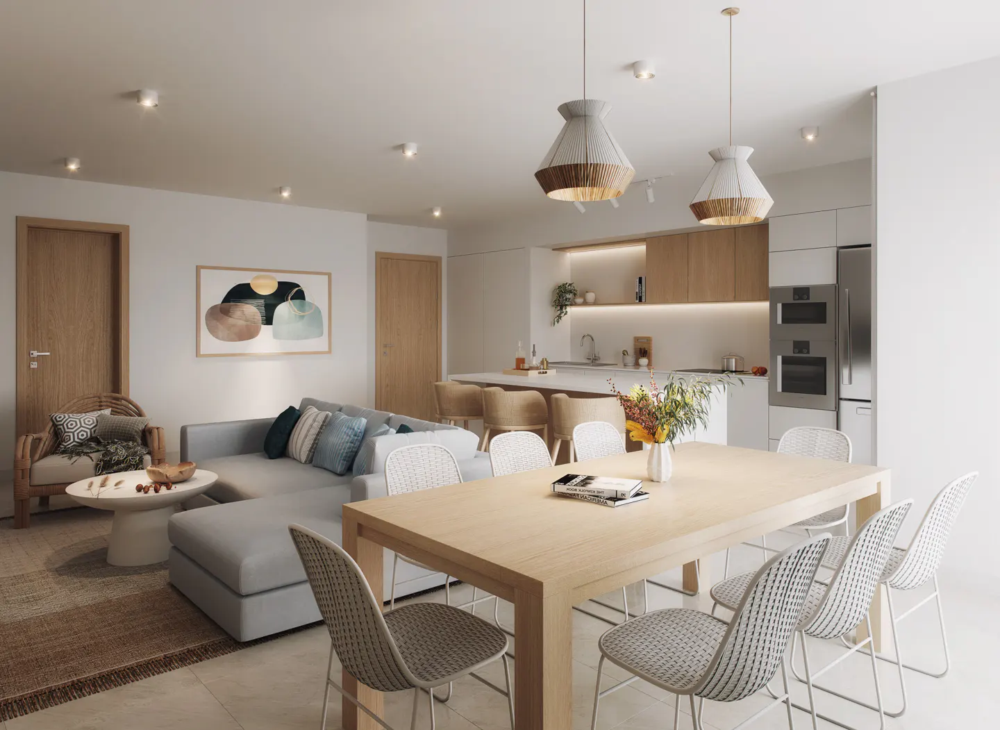 Open-concept living space with a gray sectional sofa, wood dining table, and modern kitchen. Pendant lights hang above the dining area.