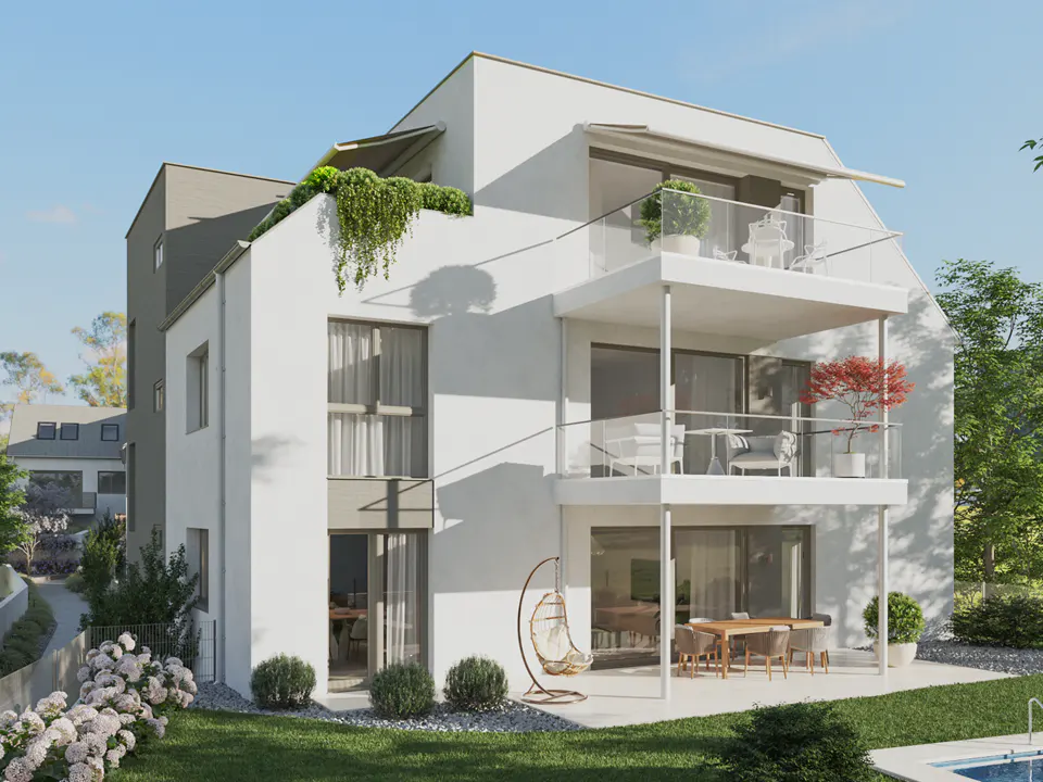 Modern white building with two balconies, outdoor furniture, and green lawn.