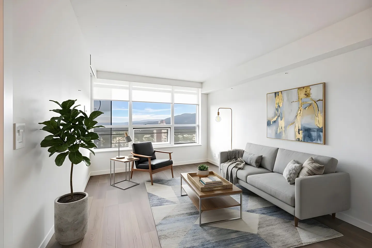 Bright living room with a gray sofa, wood chair, and a large window with a city view. A potted plant sits near the wall.