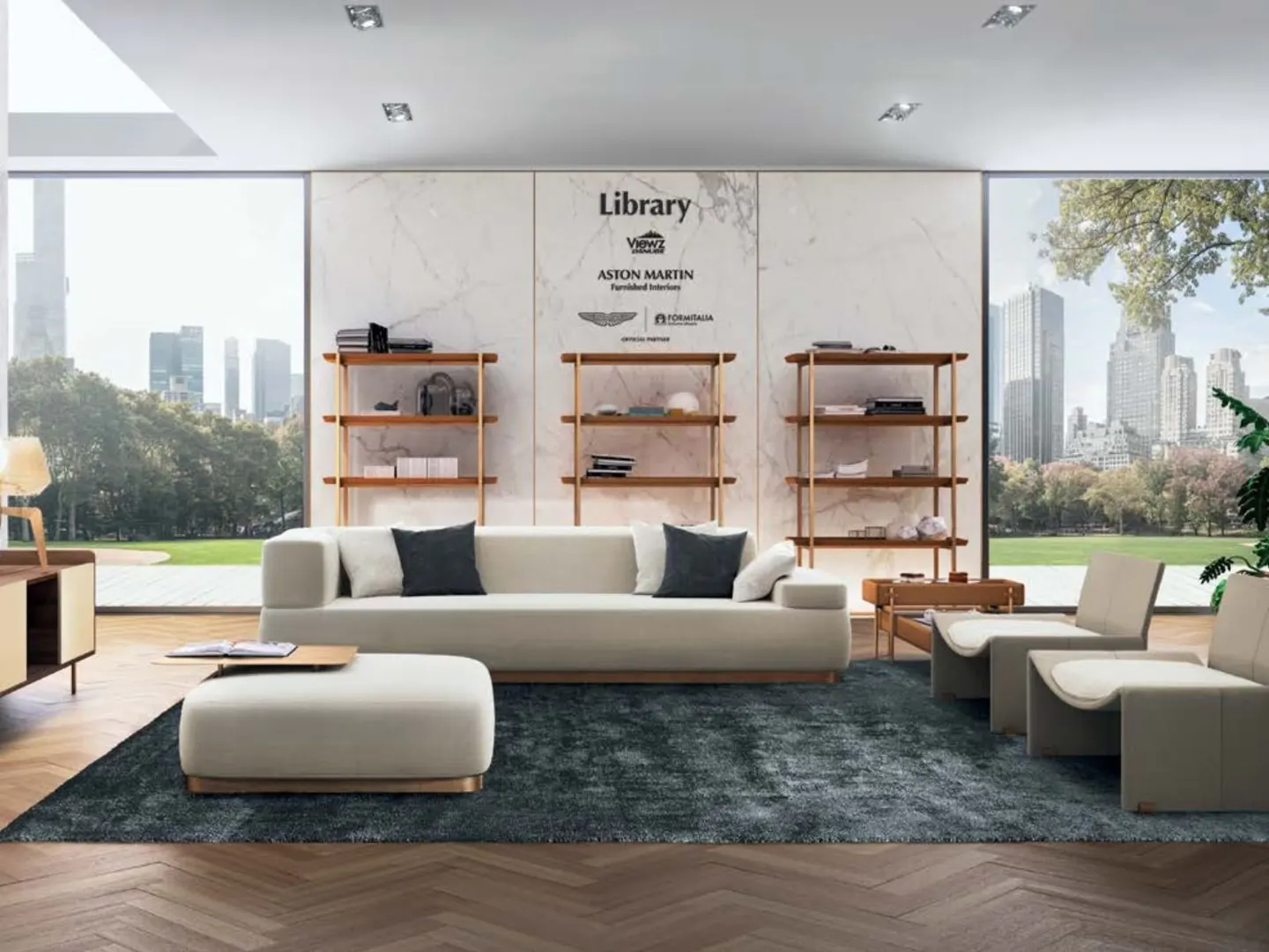 Bright living room with a cream sofa, chairs, and ottoman on a blue rug. Three wooden bookshelves stand against a marble wall. Large windows show a city view.