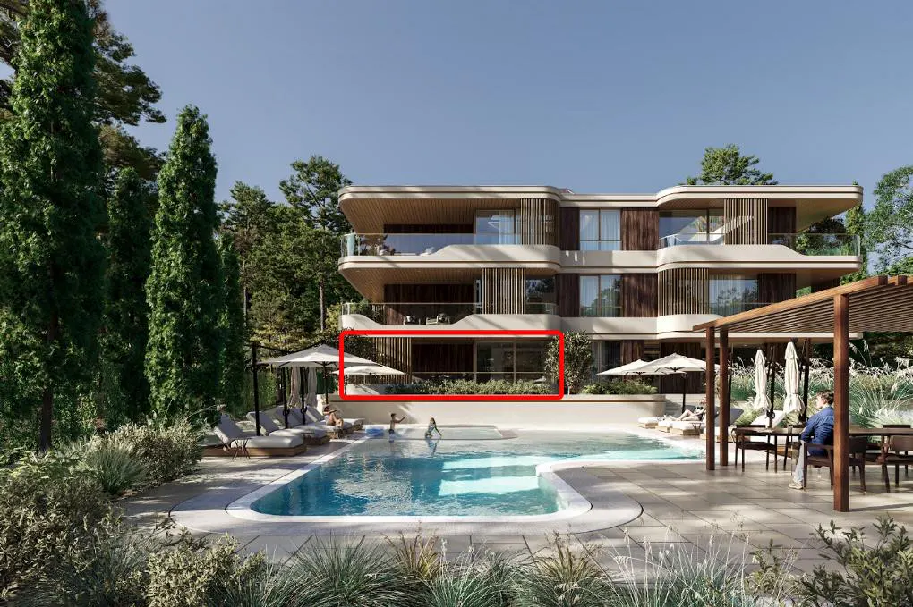 Exterior view of a modern, multi-story building with a pool, lounge chairs, and dining area. Trees surround the property.