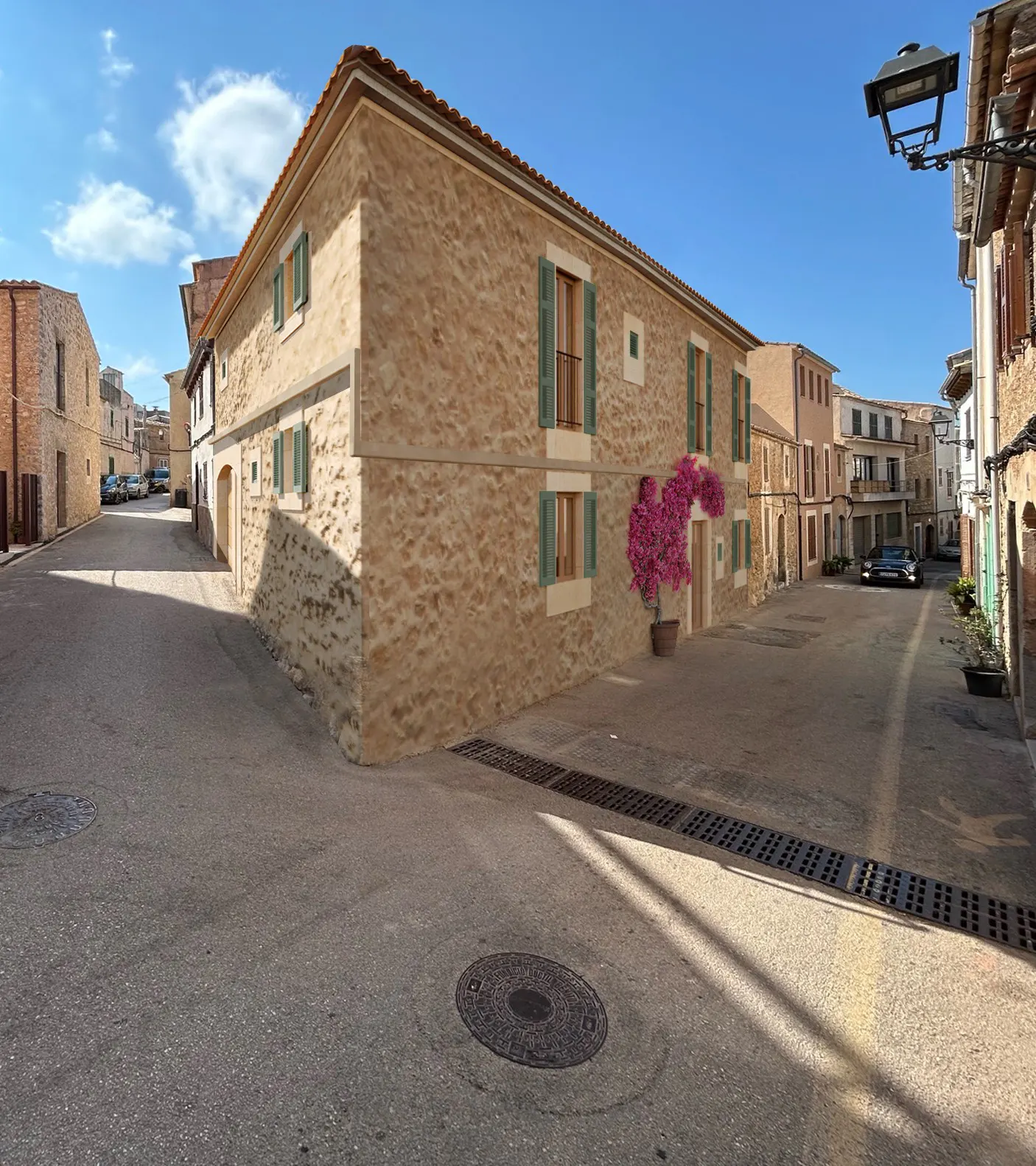 Exterior view of a stone building with green shutters and a pink bougainvillea bush on a sunny street.