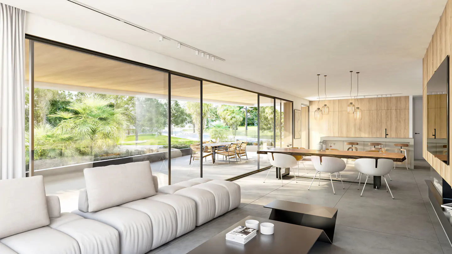 Bright, modern living room with a white sofa, large windows overlooking a green garden, and a dining area with a wooden table.