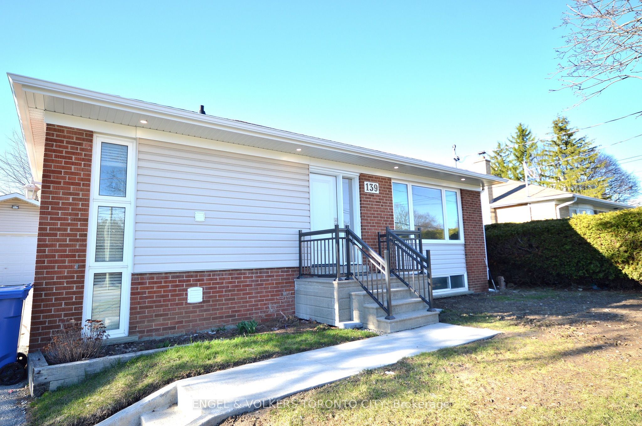 Exterior view of a single-story home with brick and siding, a small porch with black railings, and the house number 139.