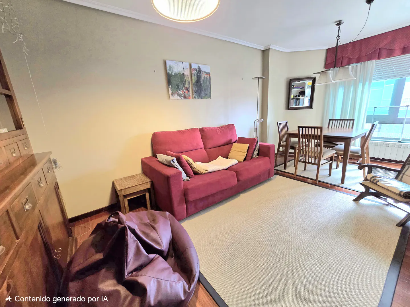 A living room with a red sofa, dining table, and a brown beanbag chair on a beige rug.