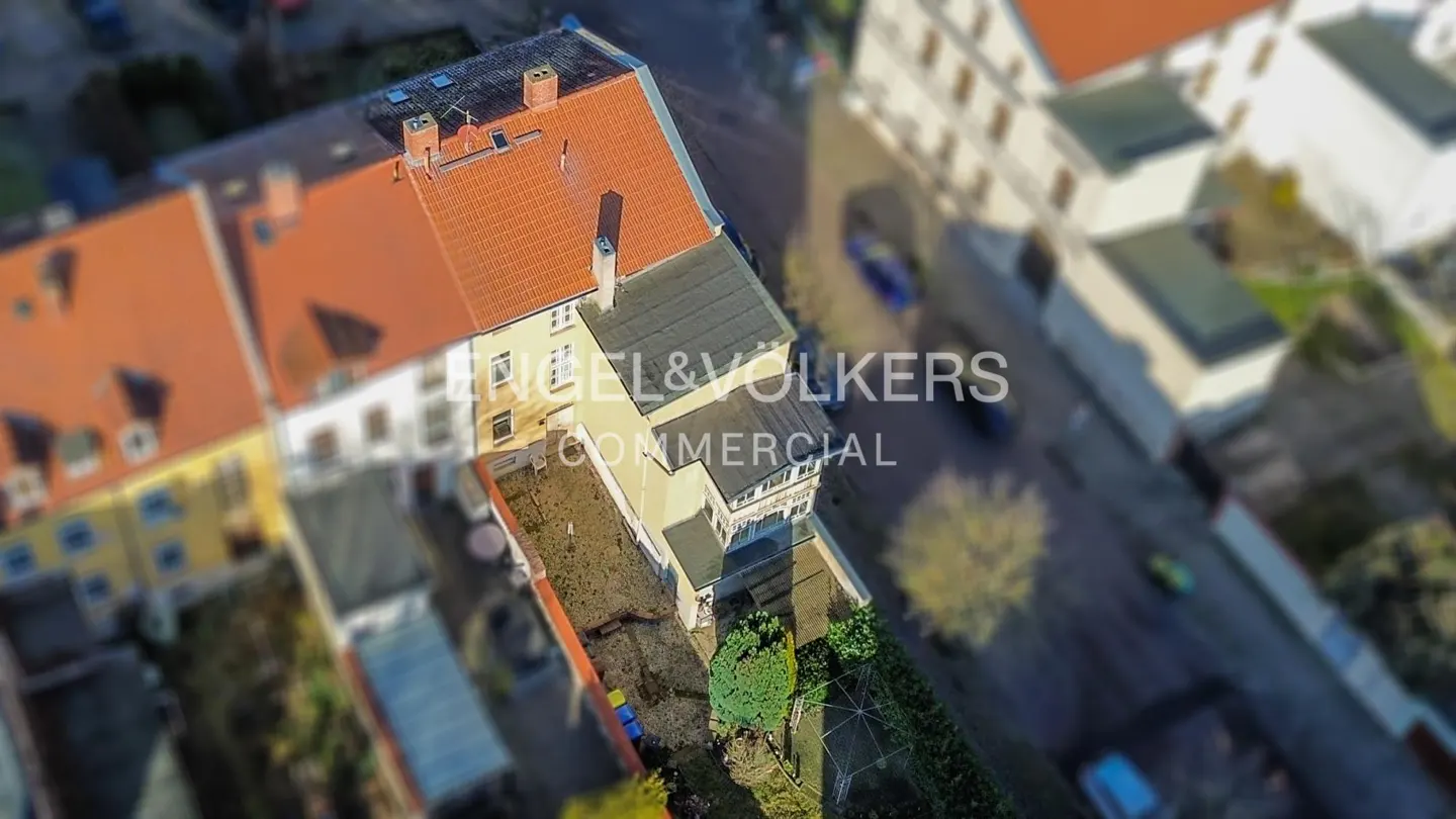 Aerial view of a commercial building with a red tile roof and the Engel & Volkers logo.