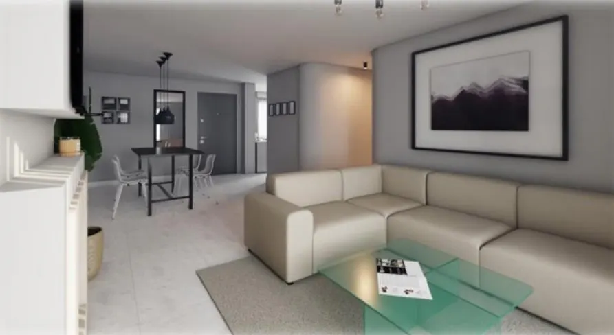 Modern living room with a beige sectional sofa, glass coffee table, and black and white art on gray walls. A dining table is visible in the background.