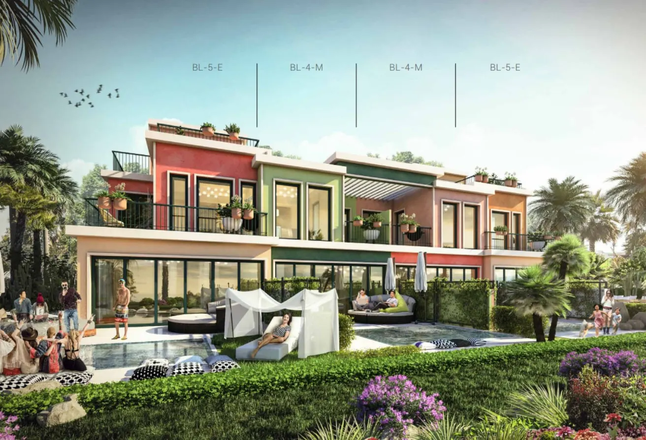 Exterior view of modern townhouses with pools, lounge areas, and lush landscaping. The buildings are painted in coral and green hues.