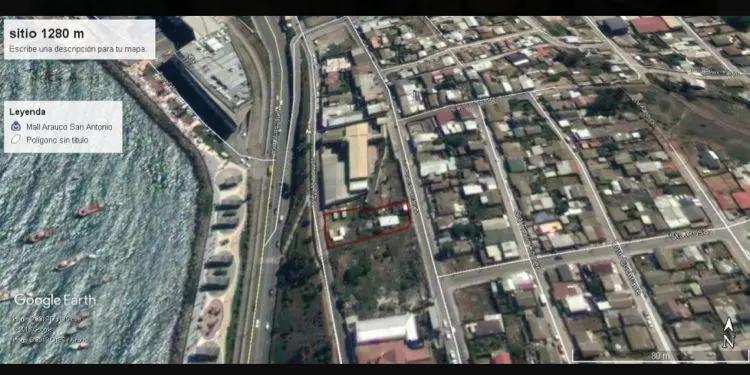 Aerial view of a property outlined in red, near a highway, ocean, and residential area.