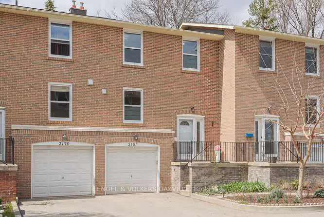 Two-story brick townhouse with white garage doors, windows, and doors. The Engel & Volkers logo is visible on the garage.