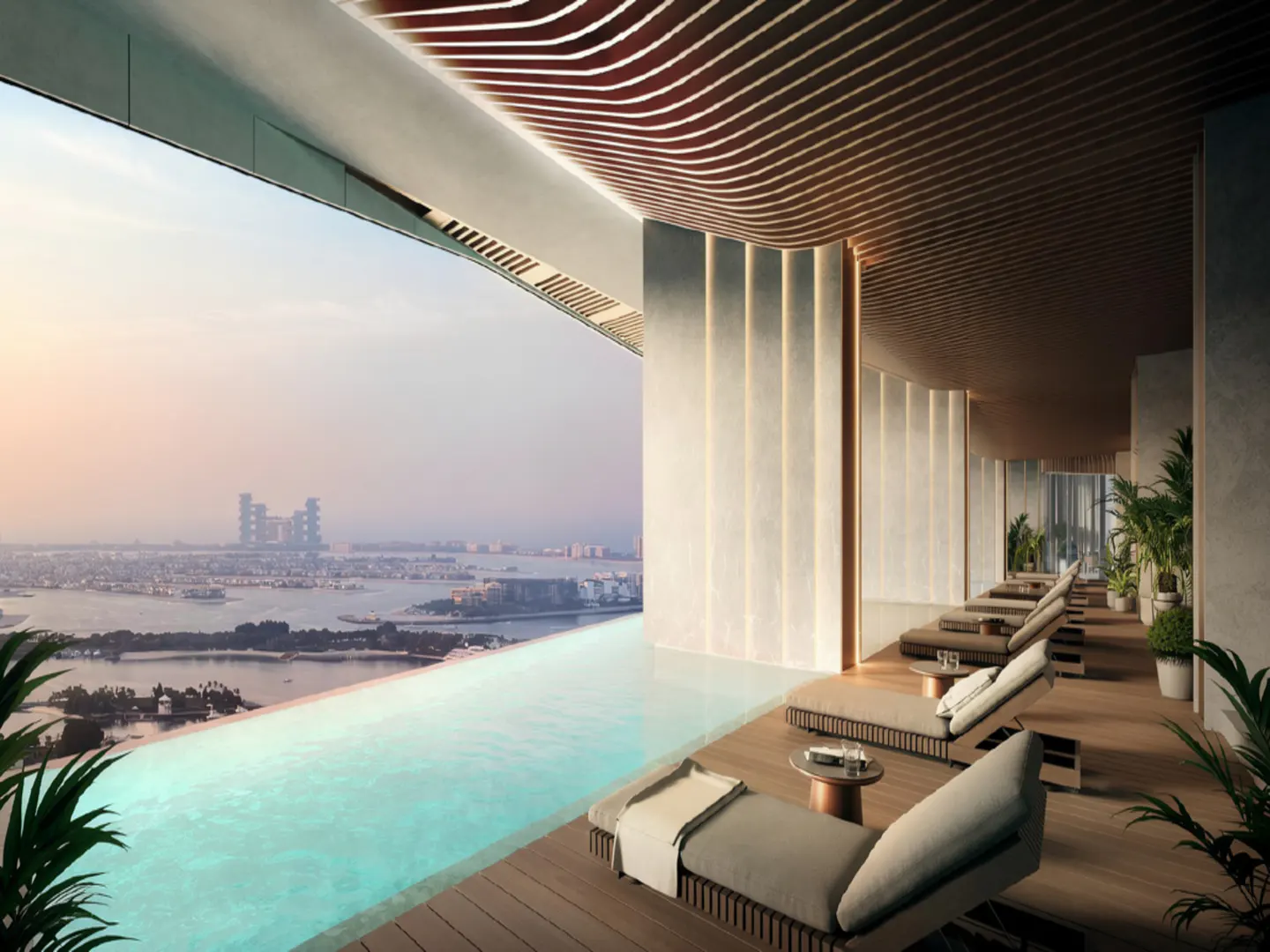 Indoor infinity pool with lounge chairs overlooking a city skyline at sunset. Wood ceiling and potted plants add to the luxurious ambiance.