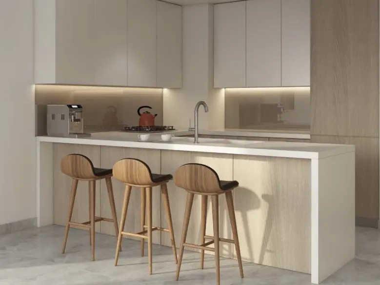 A modern kitchen with white cabinets, a white countertop, and three wooden bar stools. A coffee maker and kettle sit on the counter.