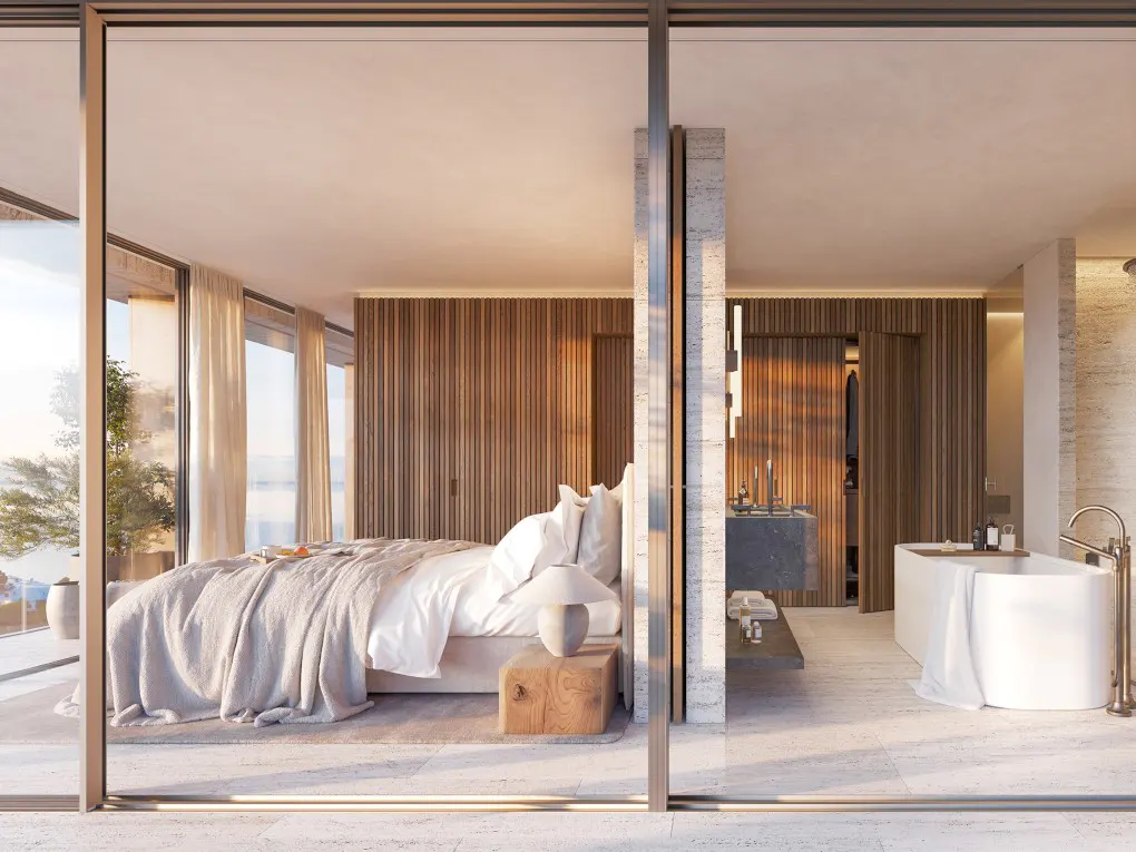 Open-concept bedroom and bathroom with wood paneling, white linens, and floor-to-ceiling windows.